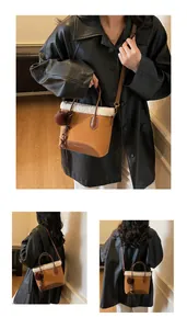 Detail of brown suede bucket bag with white shearling trim and pom-pom tassel charm