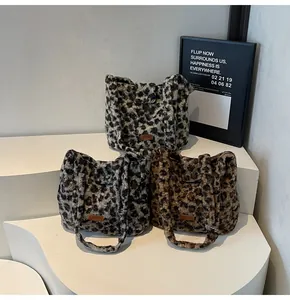 Detail of plush leopard print tote bags showing soft faux fur texture and brand labels