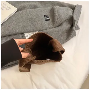 Minimalist dark brown knitted shoulder bag featuring a chunky knit texture and wide strap