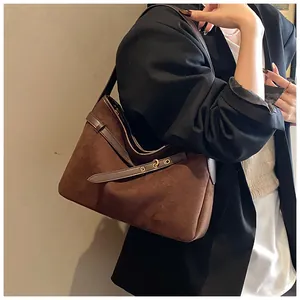 Detail of vintage faux suede tote bag featuring smooth leather straps and metal hardware