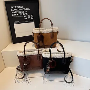 Three suede bucket bags with faux fur trim in brown, camel, and black colors