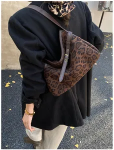 Detail of leopard print suede tote with dark brown leather strap and rivet accents