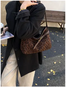 Close-up of brown leopard print suede tote with leather trim and metal buckle detail