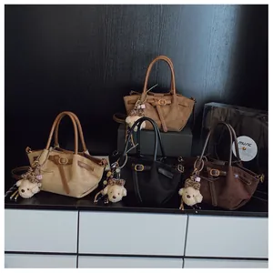 Detalle de cuatro bolsos tote de ante retro en caqui, camel, negro y café oscuro con ositos