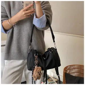 Detail der schwarzen Bowling-Tasche mit Plüschbären-Anhänger und abnehmbarem Gurt