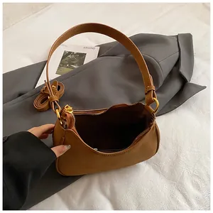 Vintage brown suede crescent underarm bag with adjustable strap on grey blazer