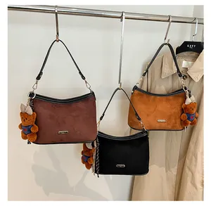 Chic hobo shoulder bags in brown and black suede with cute plush bear charms on hangers