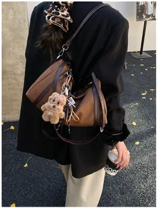 Detail der Retro-Tote-Bag mit Plüschwelpen-Anhänger im herbstlichen Streetstyle-Look