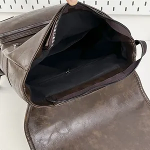 Deep brown faux leather backpack showing large interior space and zipper pocket