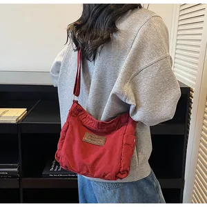 Detailed view of red canvas crossbody bag showing durable texture and metal strap adjuster