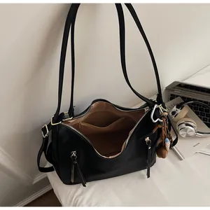 Détails de l'intérieur du sac en cuir noir avec doublure marron et poches zippées de rangement