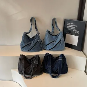 Minimalist washed denim tote bags in four colors displayed on a modern white pedestal