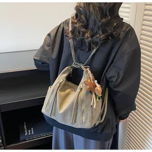 Détail du sac vintage gris avec pendentif en étoile et accessoire en peluche douce
