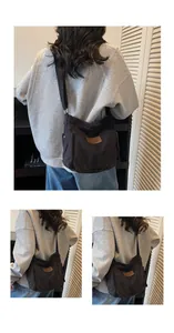 Detailed view of the adjustable shoulder strap and leather patch on black canvas bag