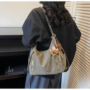 Sac hobo chic à fermetures éclair et charms ours étoile porté par un mannequin