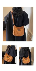 Close-up of brown canvas shoulder bag featuring a leather logo patch and side pocket
