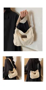 Close-up of beige canvas shoulder bag featuring side pockets and a leather logo patch