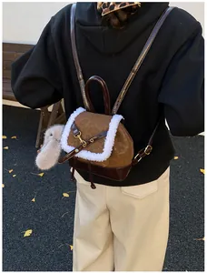 Close-up of leopard print faux shearling backpack with a cute grey bunny plush charm