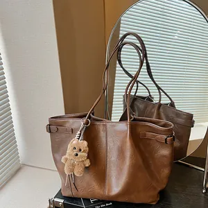 Brown faux leather tote bag with pleated texture and cute teddy bear charm for women