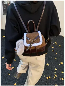 Detail view of winter suede backpack with white plush trim and a gray rabbit pendant