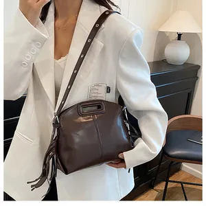 Vue détaillée du sac à main marron café poli avec pompon et œillets métalliques
