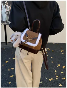 Detail view of mini suede backpack with plush faux fur trim and cute rabbit keychain