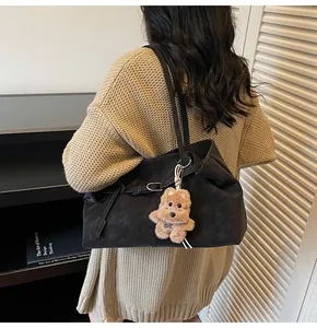 Detail der mattschwarzen Shopper-Tasche aus Ölwachs-Leder mit süßem Teddy-Anhänger