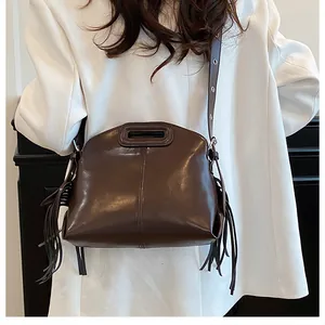 Détail du sac à main en cuir marron avec accents à franges et poignée découpée