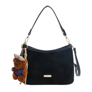 Retro black suede shoulder bag for women with a cute plush bear charm and gold logo