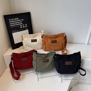 Minimalist canvas crossbody bags in five colors including cream, orange, and black finishes