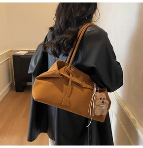 Detailansicht der karamellfarbenen Tote Bag aus Öl-Wachs-Leder mit Plüsch-Hundeanhänger