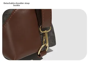 Detail of gold metal spring clasp and D-ring buckle on a brown leather and fabric tote bag