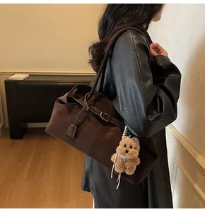 Detail der Vintage-Tragetasche aus braunem Wachsleder mit Teddybär-Anhänger und Schnalle
