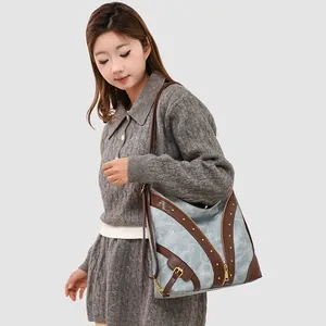 Blue marble tote bag for women with brown trim and gold studs shown on model