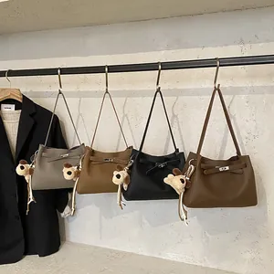 Minimalist faux leather bucket bag set in four neutral tones with dog charm and metal clasp