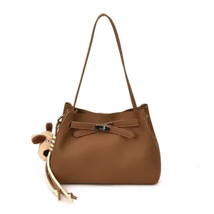Minimalist brown litchi pattern leather bucket bag with cute plush puppy keychain