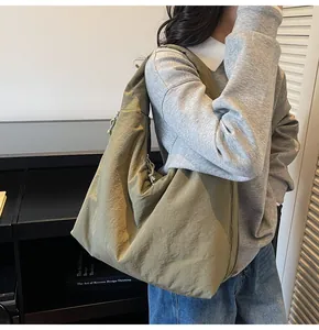 Side view of large army green nylon hobo bag featuring functional drawstring details