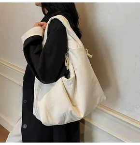 Minimalist white nylon tote bag shown on a model with natural wrinkled fabric texture