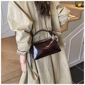 Details der dunkelbraunen glänzenden Boston-Tasche mit Silberkette und Knotengurt