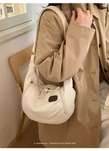 Detail of off-white nylon dumpling bag with adjustable strap and vintage brand patch