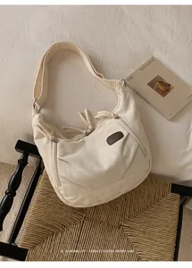 Detail of minimalist cream canvas dumpling bag on a chair with retro magazine aesthetic