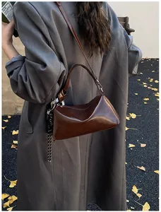 Detail der dunkelbraunen glänzenden Boston-Tasche mit gewebter Quaste im Freien