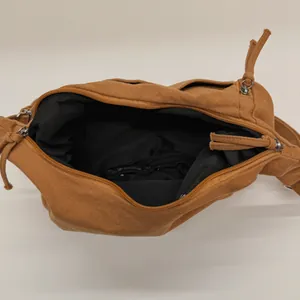 Top view of a tan nylon dumpling crossbody bag showing spacious interior and zipper pocket