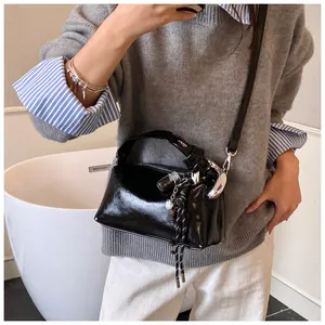 Nahaufnahme der schwarzen glänzenden Boston-Tasche mit Silberbeschlägen und Anhänger