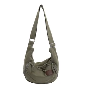 Dark green nylon dumpling bag with adjustable shoulder strap and side zipper pockets