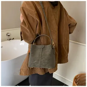 Détail du sac seau gris-vert avec surpiqûres verticales et picots de protection