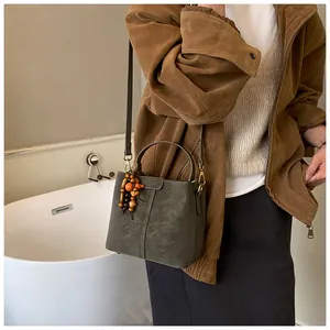 Détail du sac seau avec pendentif en perles ethniques et large bandoulière ajustable