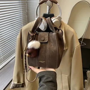 Retro dunkelbraune Beuteltasche mit weißen Nähten und flauschigem Handschuh-Anhänger