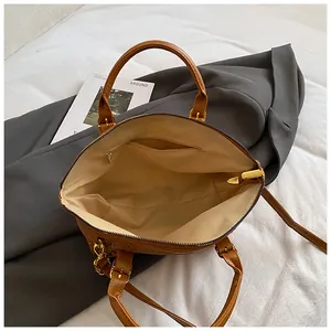 Brown vintage faux leather crossbody bag with wide zipper opening and gold hardware