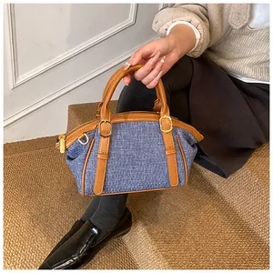 Close-up of blue and white woven texture on crossbody bag with brown leather details
